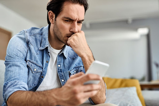 man looking at phone concerned